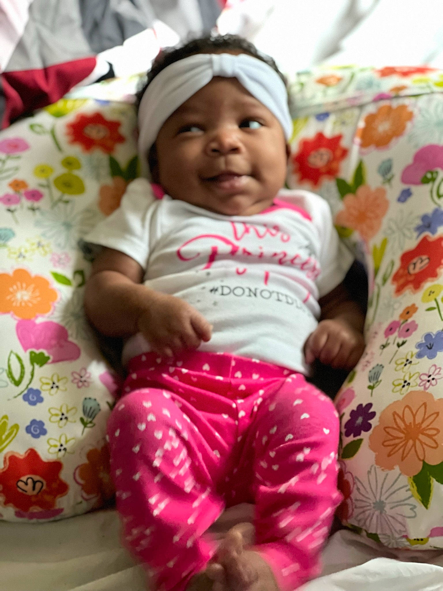 Nova is registered to the contest to win money with this photo: baby, baby_products, baby_toddler_clothing, cheek, child, comfort, face, fun, happy, head, headwear, linens, magenta, pattern, person, pink, sitting, skin, sleeve, smile