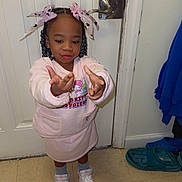 Nova joined the competition — help win amazing prizes! child, girl, braids, pink_bows, pink_outfit, sneakers, floor, door, lock, playful, pose, indoor, tiles, socks, cartoon_print, hand_gesture, smile, young_child, casual_clothing, home