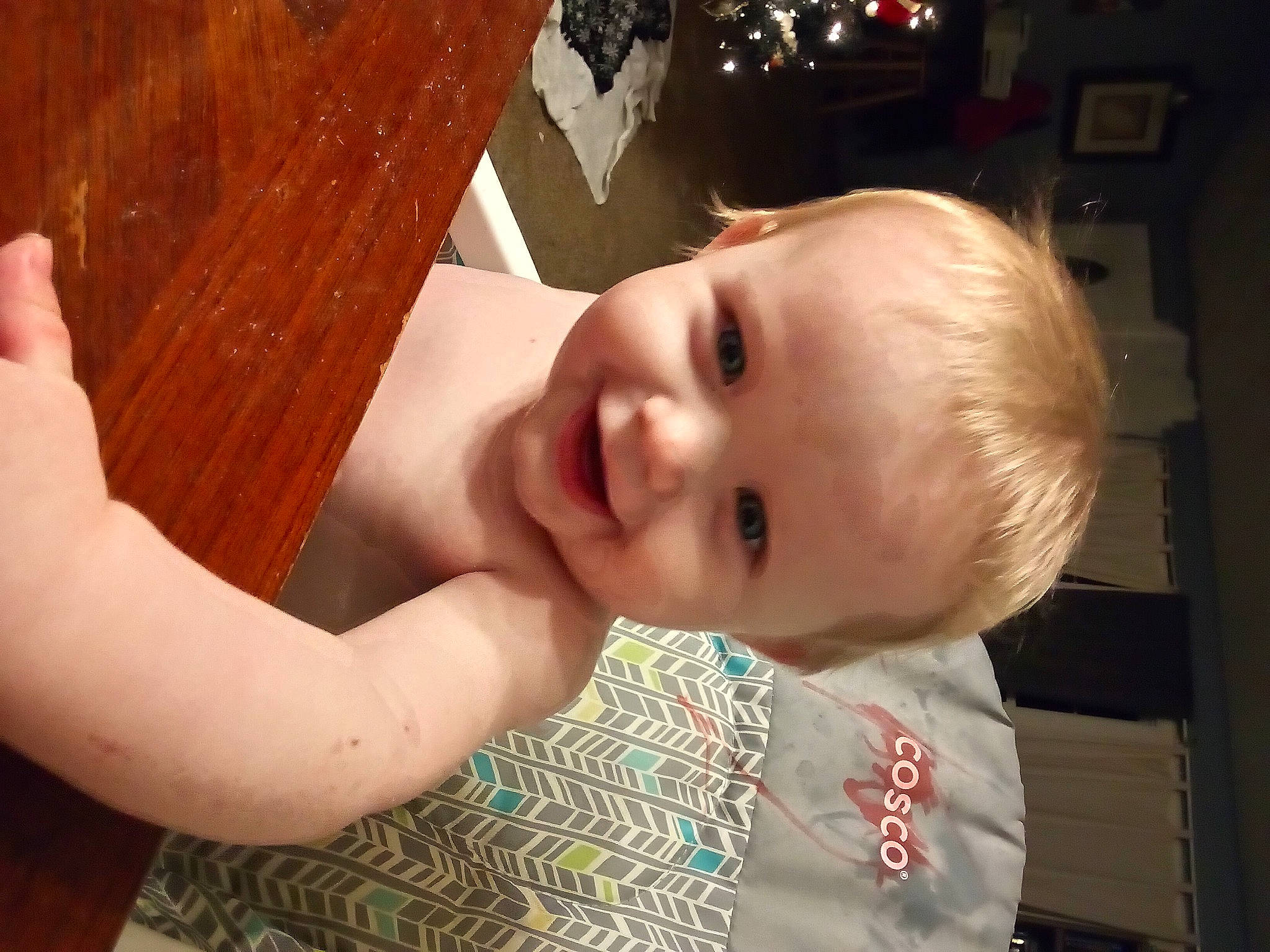 Ashton is registered to the contest to win money with this photo: baby, baby_toddler_clothing, cheek, child, dress, face, finger, fun, gesture, hand, happy, human_body, iris, joy, mouth, nose, person, skin, smile, standing