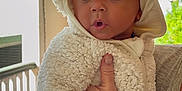 J Pierce joined the competition — help win amazing prizes! baby, child, infant, onesie, hood, ears, fluffy_clothing, hand, freckles, indoor, window, natural_light, curious_expression, surprised_face, person, portrait, cute, soft_texture, warm_clothing, holding