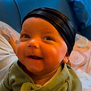 J Pierce is registered to the contest to win money with this photo: baby, infant, smile, green_onesie, headband, chubby_cheeks, happy, indoor, person, couch, blue_couch, child, cute, portrait, human, clothing, baby_clothes, holding, closeup, face