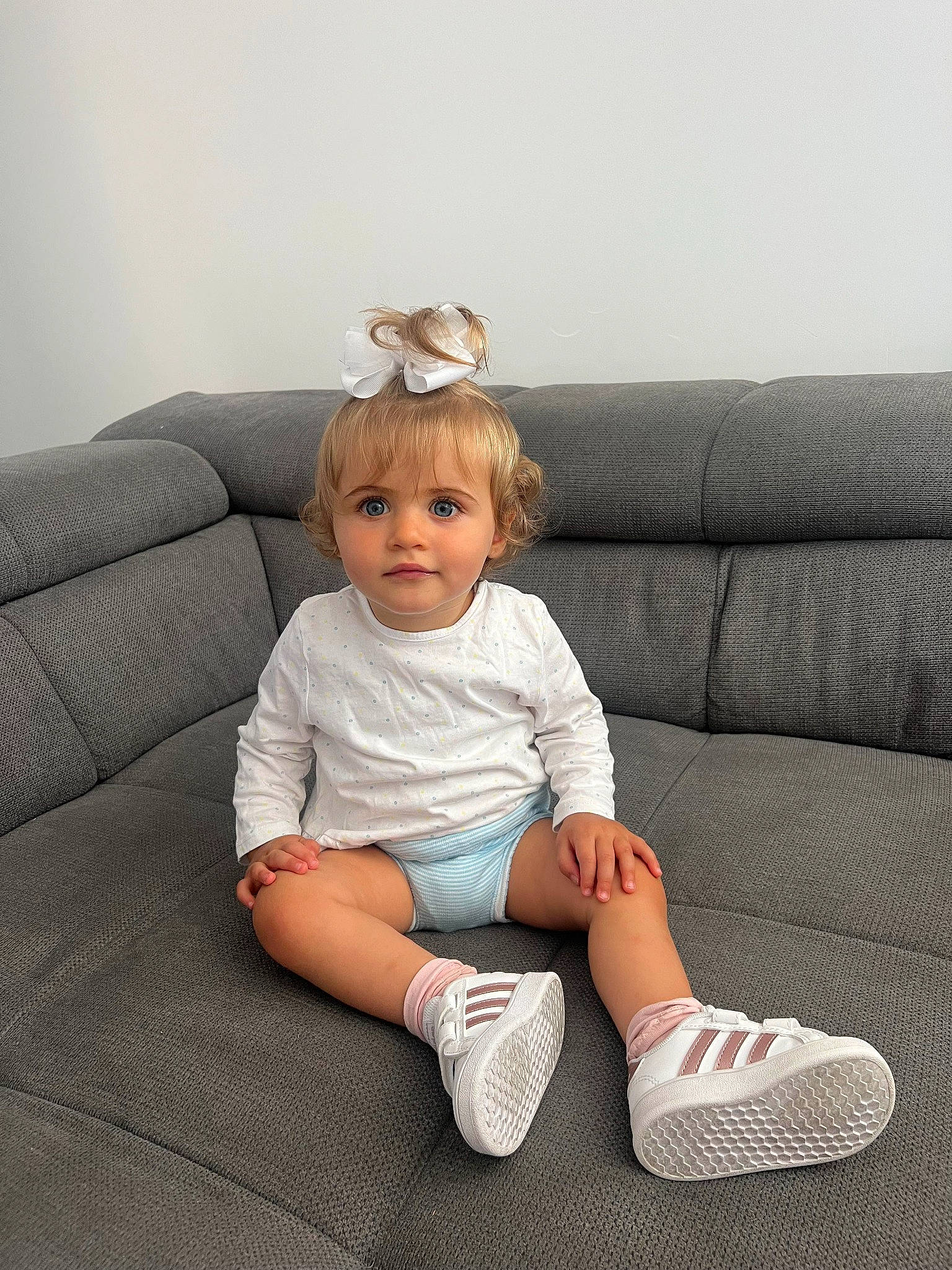 Alba participe au concours pour gagner de l'argent avec cette photo : baby, baby_toddler_clothing, comfort, couch, elbow, foot, grey, human_leg, knee, leg, pattern, person, rectangle, sitting, sleeve, sock, sofa_bed, studio_couch, t_shirt, thigh