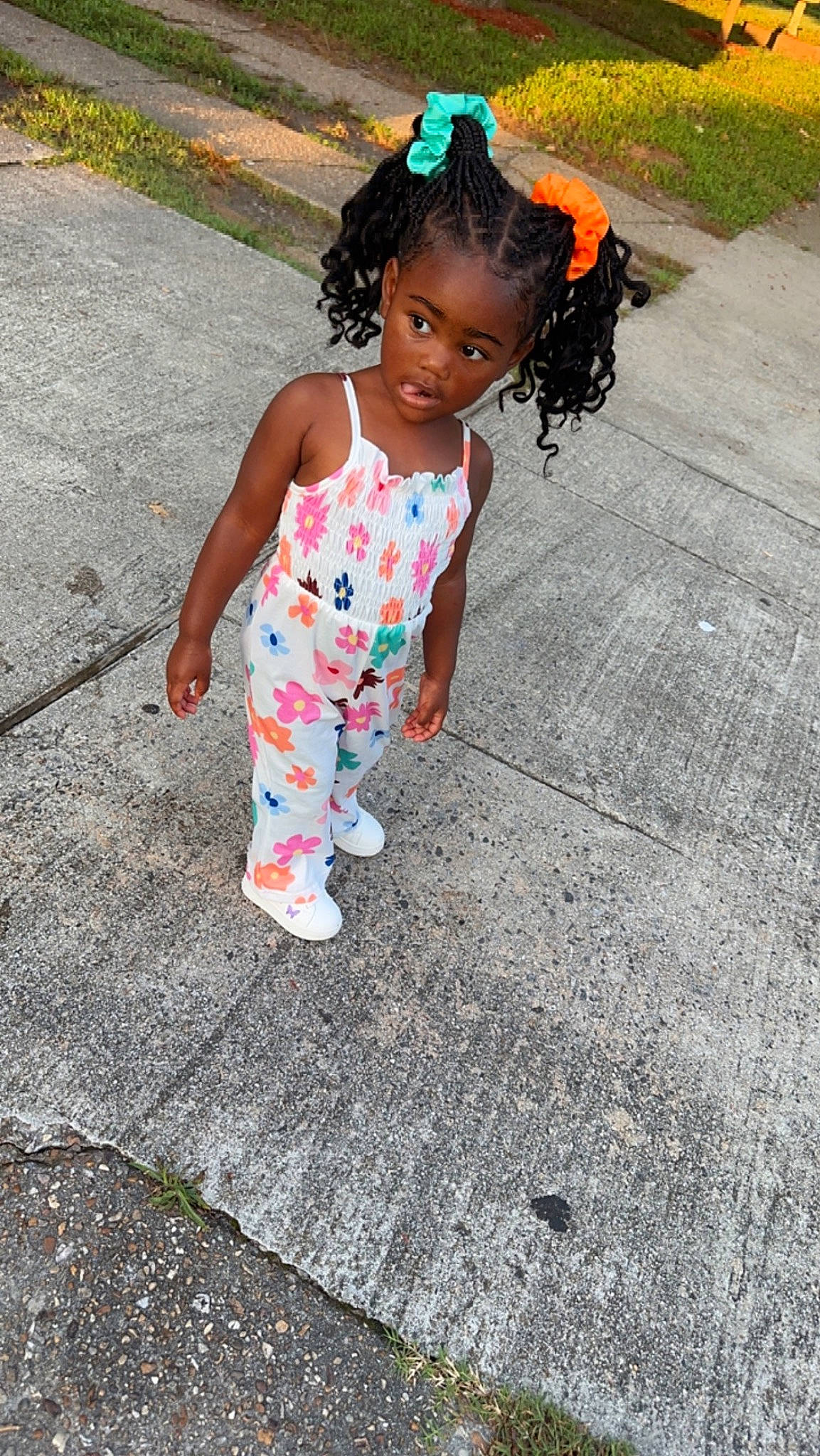 Charm is registered to the contest to win money with this photo: asphalt, baby, baby_toddler_clothing, child, foot, fun, grass, hairstyle, happy, head, human_leg, person, play, road, road_surface, sandal, sidewalk, smile, thigh, toddler