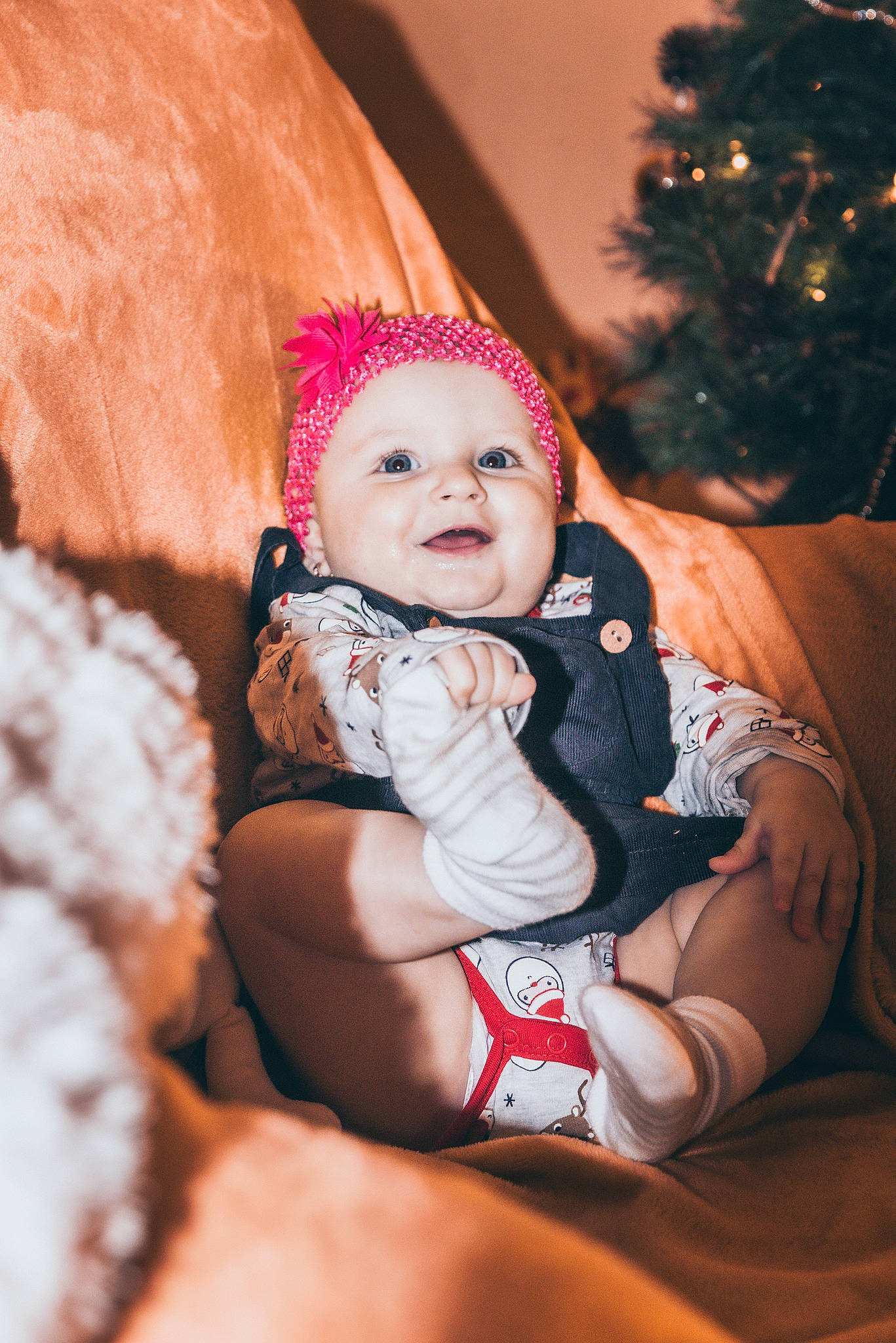Francesca is registered to the contest to win money with this photo: baby, baby_toddler_clothing, cap, child, christmas_tree, comfort, event, eye, face, flash_photography, fun, happy, headwear, human_body, lap, leg, person, sitting, smile, sock