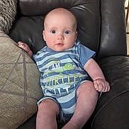 Rori joined the competition — help win amazing prizes! baby, infant, blue_eyes, onesie, striped_clothing, couch, leather_couch, pillow, indoor, child, cute, sitting, expression, face, skin, foot, hand, comfortable, home, portrait