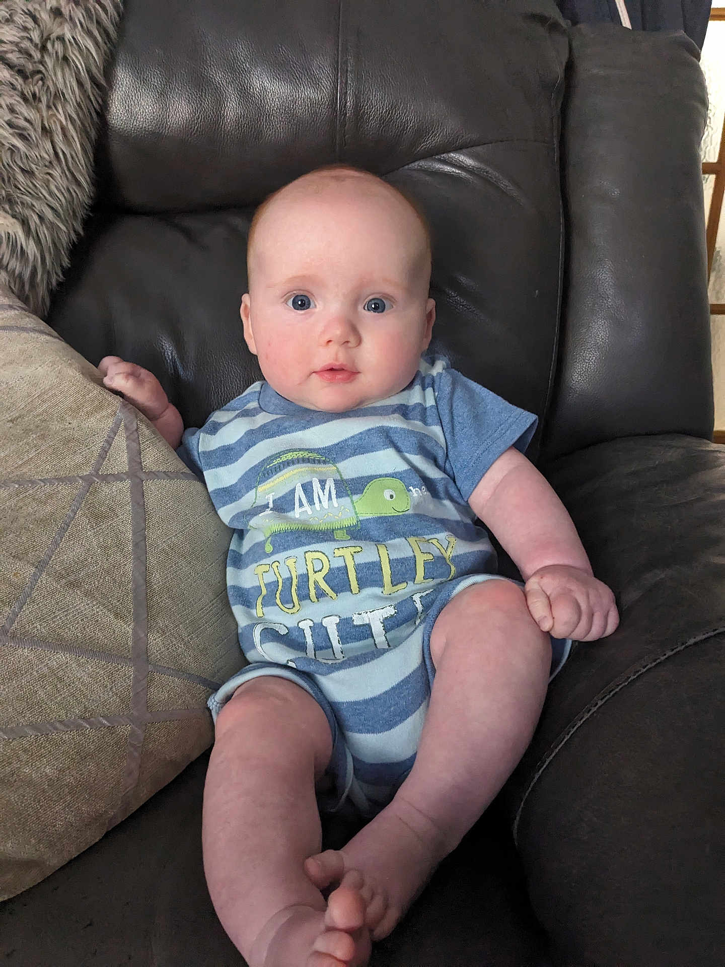 Rori joined the competition — help win amazing prizes! baby, infant, blue_eyes, onesie, striped_clothing, couch, leather_couch, pillow, indoor, child, cute, sitting, expression, face, skin, foot, hand, comfortable, home, portrait
