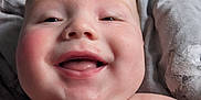 Rori joined the competition — help win amazing prizes! baby, blanket, cheeks, child, closeup, cute, eyes, face, happy, head, indoors, infant, lying_down, naked_torso, portrait, shoulders, skin, smiling, texture, tongue