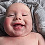 baby, blanket, cheeks, child, closeup, cute, eyes, face, happy, head, indoors, infant, lying_down, naked_torso, portrait, shoulders, skin, smiling, texture, tongue
