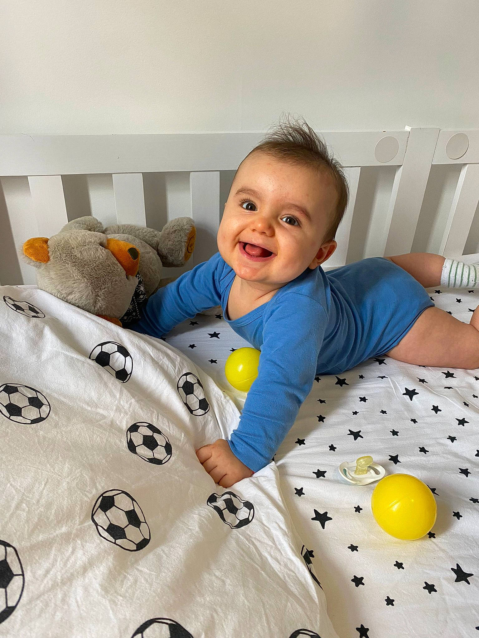 Damian a rejoint le concours — aidez-le/la à gagner de superbes lots ! baby, baby_products, baby_toddler_clothing, bed, bed_sheet, bedding, child, comfort, facial_expression, flooring, happy, joy, linens, pattern, person, pillow, room, sleeve, smile, t_shirt