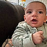 Sebastian is registered to the contest to win money with this photo: baby, child, infant, face, eyes, hand, clothing, onesie, indoor, lamp, window, blinds, couch, person, portrait, expression, curious, young, skin, home