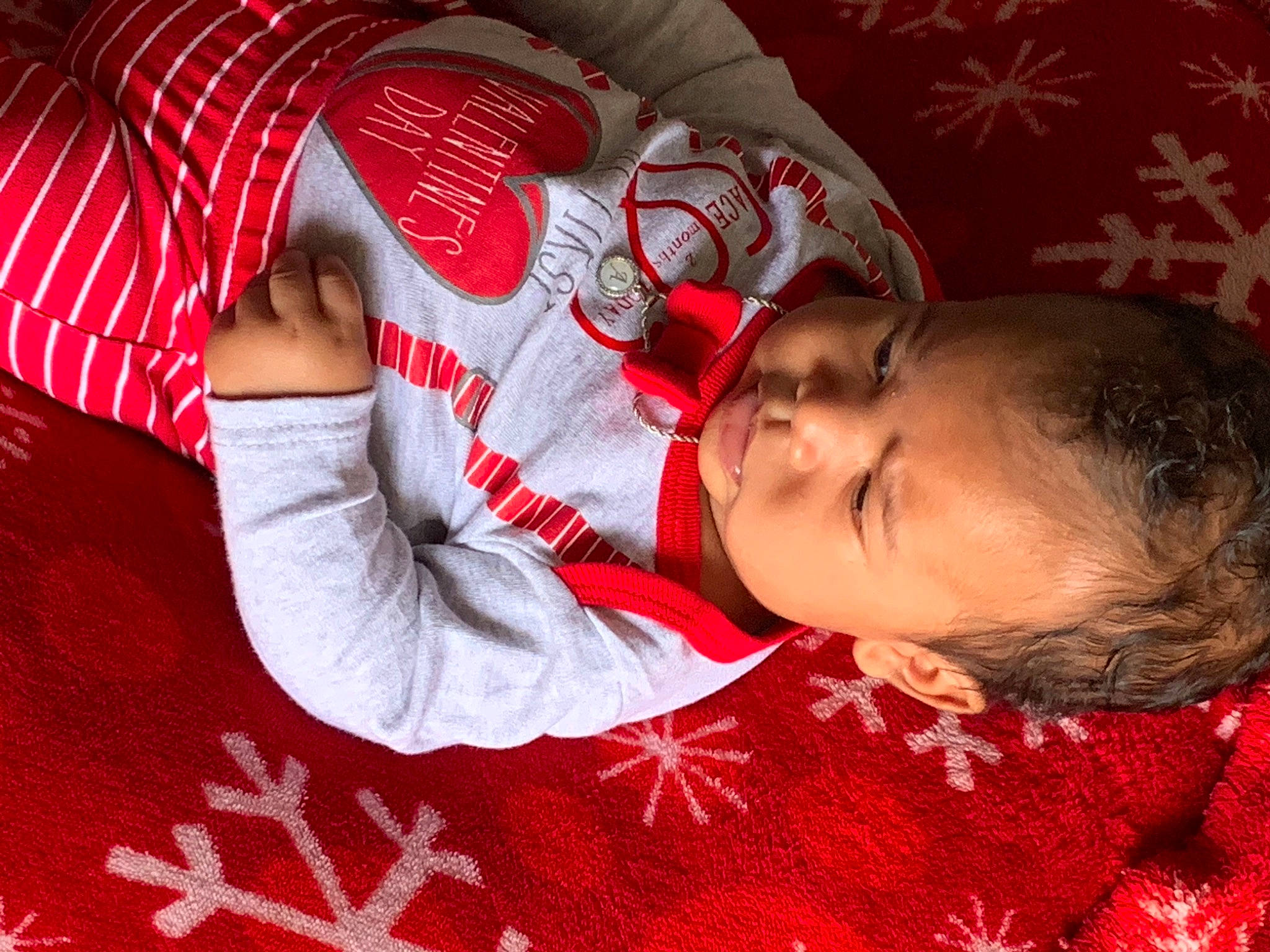 Ace is registered to the contest to win money with this photo: baby, baby_toddler_clothing, child, comfort, elbow, event, facial_expression, flash_photography, gesture, happy, head, human_body, linens, mouth, orange, pattern, person, red, skin, sleeve