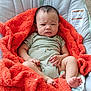 baby, blanket, carpet, child, clothing, comfort, cushion, cute, expression, face, foot, hand, indoors, infant, orange, pacifier, person, portrait, resting, seat