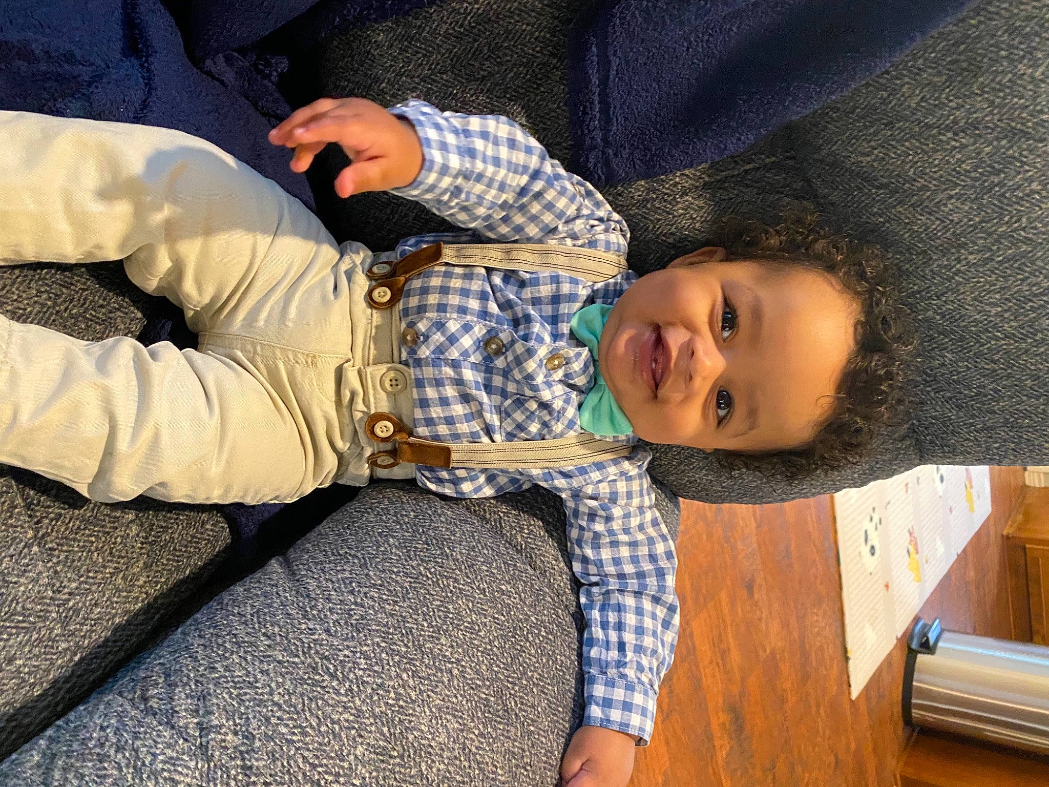 Evans is registered to the contest to win money with this photo: baby_toddler_clothing, child, comfort, cool, elbow, facial_expression, finger, flooring, gesture, hairstyle, happy, head, human_leg, joy, pattern, person, plaid, sitting, sleeve, smile