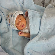 Luis Daniel Pulido is registered to the contest to win money with this photo: newborn, baby, sleeping, infant, portrait, blanket, blue_blanket, bed, pillow, indoors, cozy, peaceful, swaddled, bonnet, closed_eyes, face, hand, nursery, soft_texture, photography