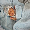 newborn, baby, sleeping, infant, portrait, blanket, blue_blanket, bed, pillow, indoors, cozy, peaceful, swaddled, bonnet, closed_eyes, face, hand, nursery, soft_texture, photography
