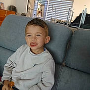 Julyan a rejoint le concours — aidez-le/la à gagner de superbes lots ! boy, candid, casual, child, couch, family, fridge, furniture, hair, interior, kitchen, living_room, lollipop, portrait, sitting, smile, snack, sweater, teeth, window_blinds
