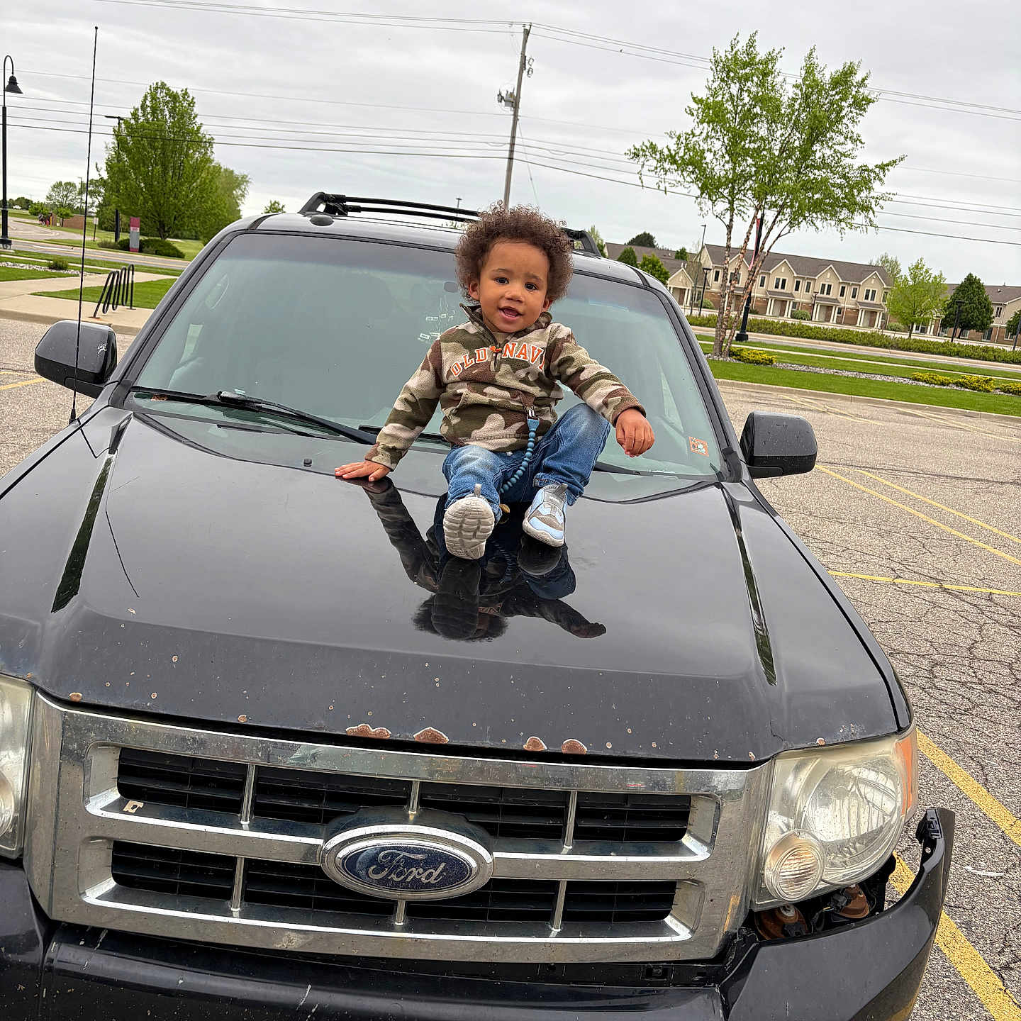 Jkheel joined the competition — help win amazing prizes! car, casual_wear, child, clothing, curly_hair, ford, hood, outdoor, overcast_sky, parking_lot, reflection, residential_area, road, sidewalk, smiling, sneakers, toddler, tree, urban, vehicle