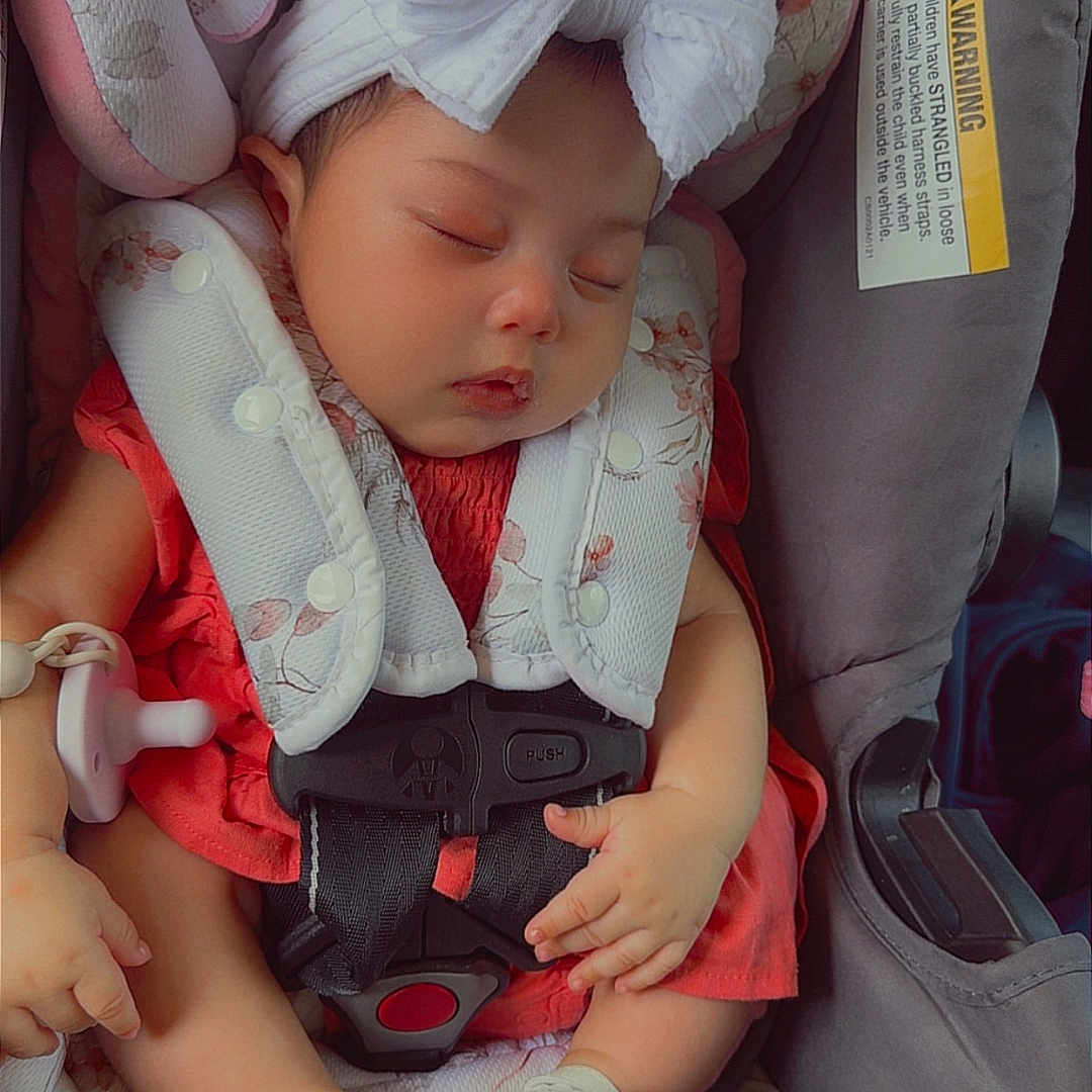 Jamilah is registered to the contest to win money with this photo: baby, sleeping, car_seat, headband, bow, red_dress, sandals, infant, peaceful, child, seatbelt, cute, small_feet, indoors, resting, safety, adorable, portrait, child_seat, comfort