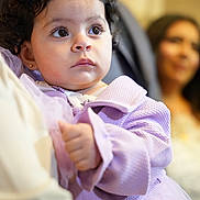 Naya joined the competition — help win amazing prizes! toddler, child, curly_hair, purple_clothing, portrait, indoor, person, baby, cute, young_child, expression, holding, family, soft_focus, warm_lighting, face, people, apparel, closeup, serious