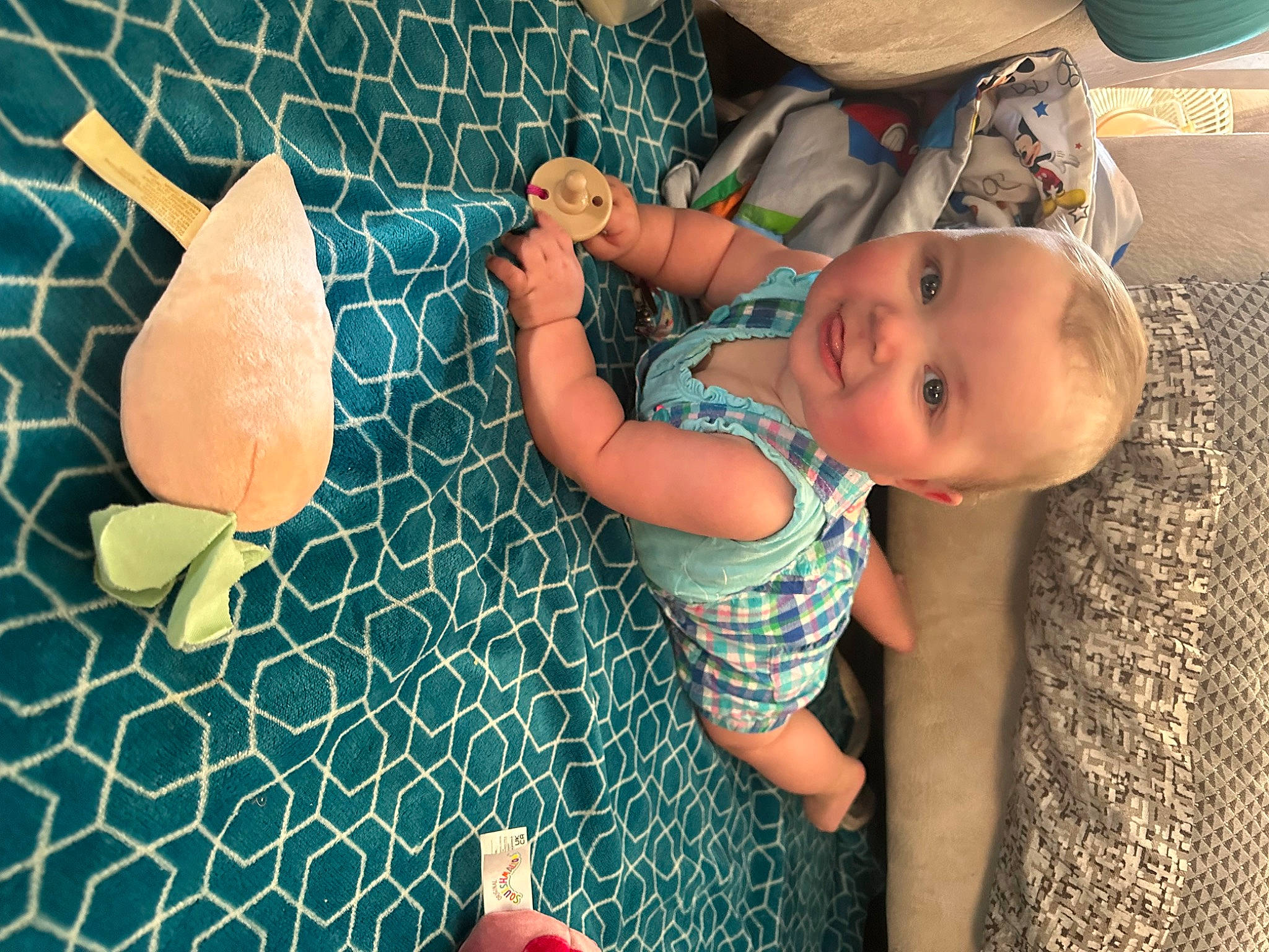 Megan is registered to the contest to win money with this photo: baby, baby_toddler_clothing, child, circle, finger, flooring, fun, gesture, grass, happy, hat, linens, nail, pattern, person, play, sitting, sun_hat, textile, thumb