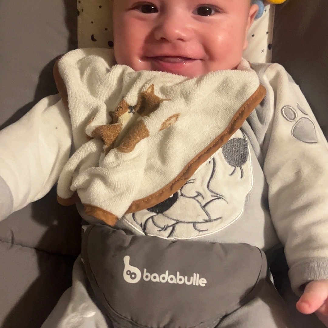 Mylo a rejoint le concours — aidez-le/la à gagner de superbes lots ! baby, smiling, infant, pajamas, bib, plush_toys, star, yellow, white, cushion, face, person, child, happy, indoor, cute, clothing, lying_down, babysuit, comfort