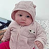 Elena a rejoint le concours — aidez-le/la à gagner de superbes lots ! baby, child, hooded_jacket, pink_clothing, infant, cute, chubby_cheeks, indoor, bed, patterned_bedding, portrait, soft_texture, warm_clothing, person, face, hand, seated, expressionless, cozy, adorable