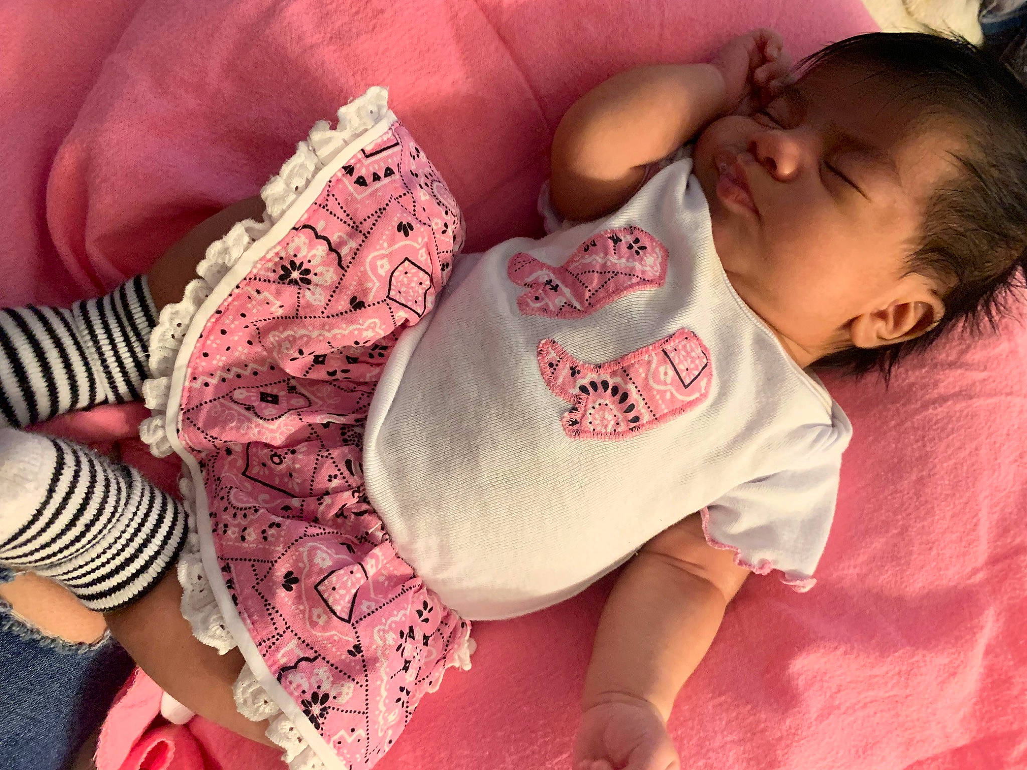 Abriella is registered to the contest to win money with this photo: baby, baby_sleeping, baby_toddler_clothing, black_hair, comfort, eyelash, finger, hand, happy, human_body, lip, mouth, nail, neck, person, pink, skin, sleeve, textile, thigh