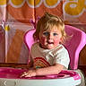 Everleigh is registered to the contest to win money with this photo: toddler, child, high_chair, pink, white_tshirt, rainbow, floral_pants, blue_eyes, rosy_cheeks, indoor, colorful_background, daisy, smiling, happy, person, seated, young_child, cute, portrait, baby