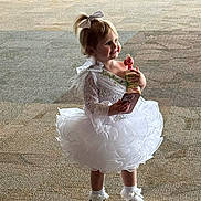 Everleigh joined the competition — help win amazing prizes! toddler, child, dress, white_dress, toy, phone, smile, indoor, carpet, footwear, socks, ribbon, bow, happy, girl, person, cute, standing, playful, portrait
