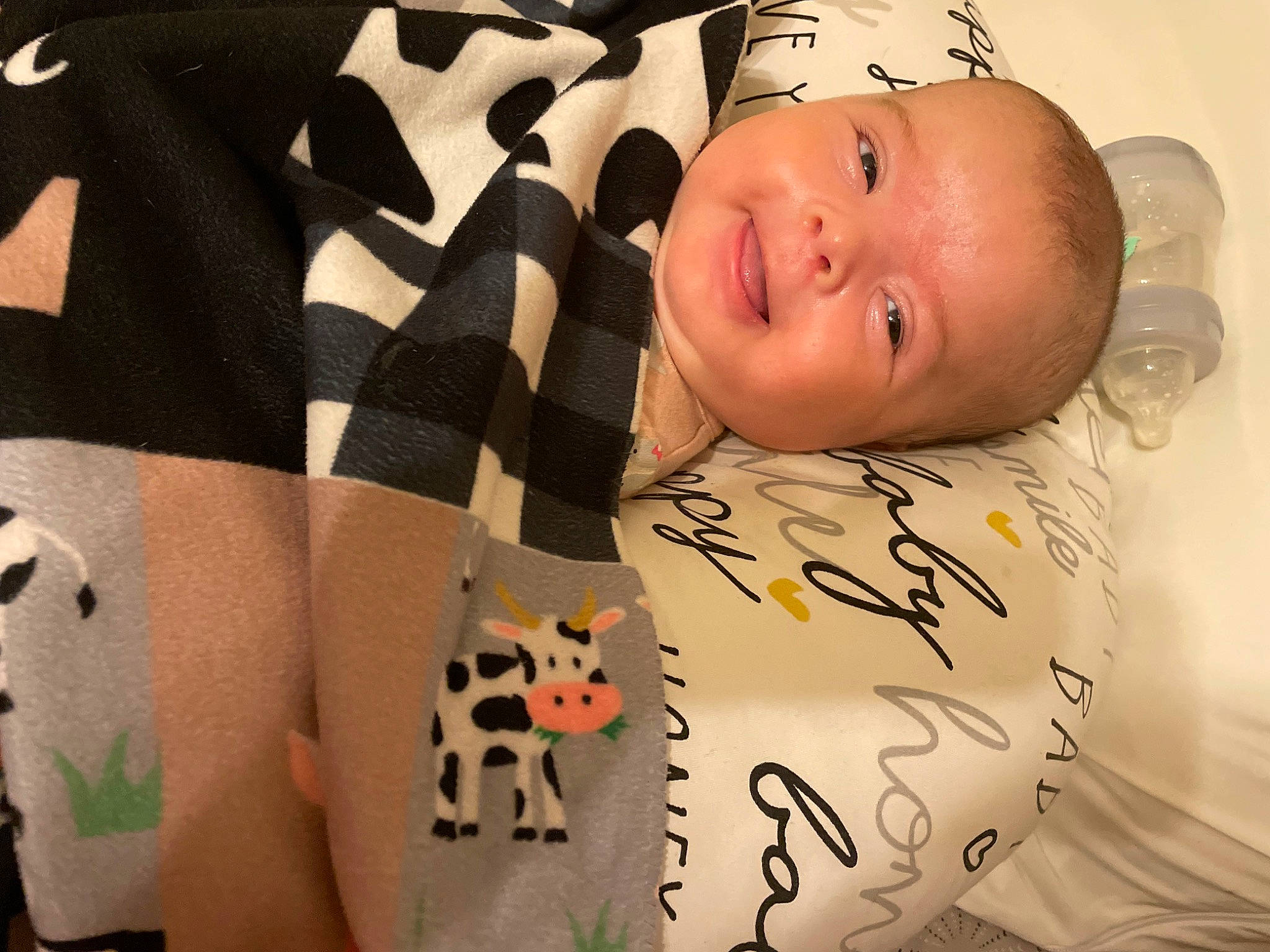 Tatum is registered to the contest to win money with this photo: baby, baby_products, baby_safety, baby_toddler_clothing, bedding, cat, comfort, felidae, finger, happy, linens, pattern, person, product, skin, sleeve, small_to_medium_sized_cats, smile, textile, toddler