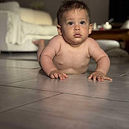 Nolan participe au concours pour gagner de l'argent avec cette photo : baby, child, floor, indoor, couch, living_room, curious, skin, face, hands, eyes, tile, home, furniture, table, young, portrait, infant, person, cute