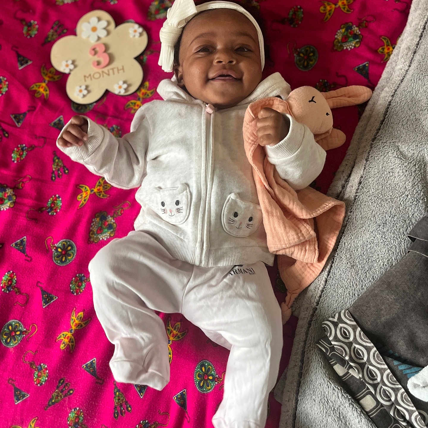 Djena participe au concours pour gagner de l'argent avec cette photo : baby, infant, smiling, white_clothing, headband, toy, stuffed_animal, blanket, pink, patterned, milestone, 3_month, lying_down, cute, child, happy, soft_toy, fabric, indoor, portrait