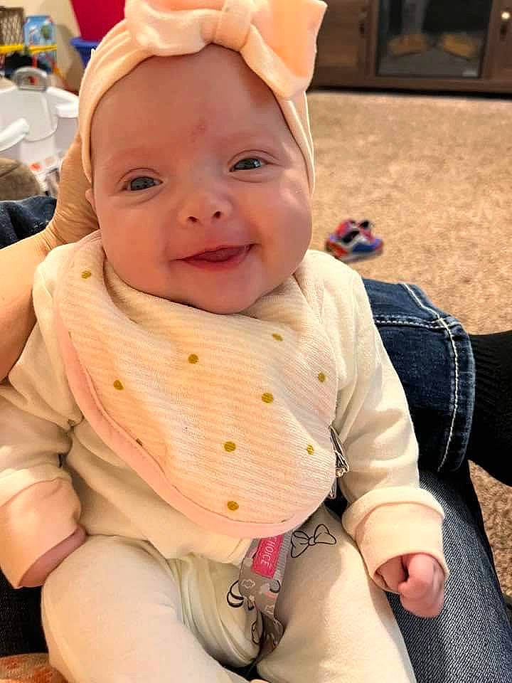 Kenzi is registered to the contest to win money with this photo: baby, baby_toddler_clothing, cap, cheek, child, facial_expression, flooring, fun, grass, happy, headgear, human_body, lip, pattern, person, pink, skin, sleeve, smile, toddler