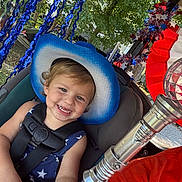 Mason joined the competition — help win amazing prizes! toddler, child, smile, hat, cowboy_hat, car_seat, seatbelt, blue, stars, outdoor, decoration, streamers, red_white_blue, festive, metallic_object, lightsaber, person, celebration, happy, portrait