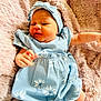 baby, blanket, bodypart, bonnet, clothing, face, finger, hand, happy, hat, head, hood, newborn, person, photography, portrait, quilt, shorts, sitting, sleeping