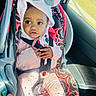 Riyah is registered to the contest to win money with this photo: toddler, child, car_seat, seatbelt, hood, bow, ears, pink_clothing, leggings, hearts, car_interior, window, daylight, sitting, cute, baby, safety, pattern, colorful, portrait