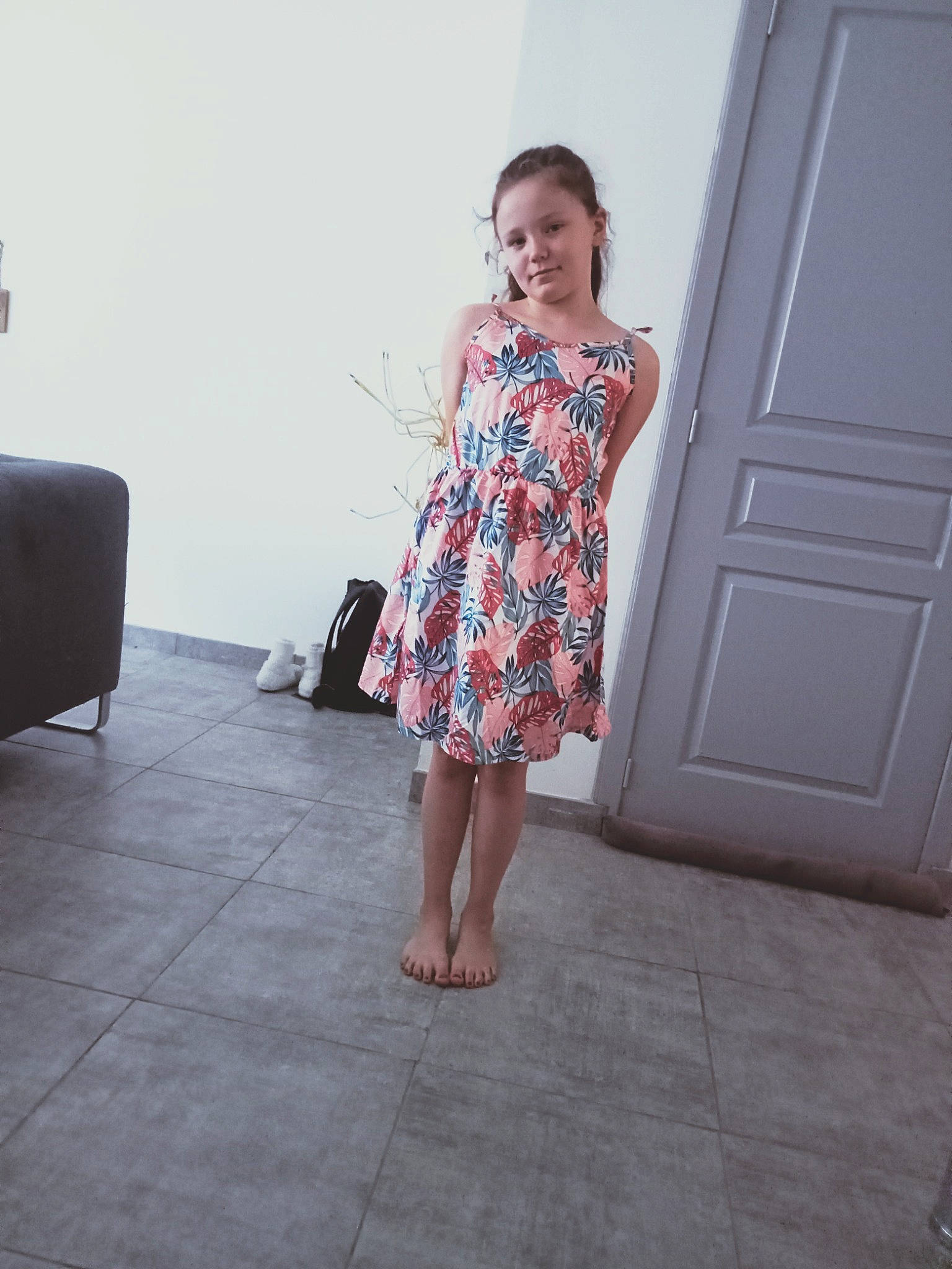 Emmy participe au concours pour gagner de l'argent avec cette photo : barefoot, day_dress, door, dress, event, fashion_design, floor, flooring, foot, human_leg, joint, joy, leg, one_piece_garment, pattern, person, purple, shoulder, standing, thigh