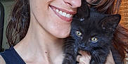Artemis is registered to the contest to win money with this photo: affection, black_cat, cat, closeup, earlobe_plugs, face, glasses, hair, happy, holding, indoor, kitten, light, person, pet, smile, tank_top, window, wooden_cabinet, young_adult