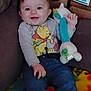 baby, child, smile, winnie_the_pooh, stuffed_toy, couch, blanket, clothing, jeans, indoor, happy, person, face, toy, seated, young_child, home, colorful, cute, infant