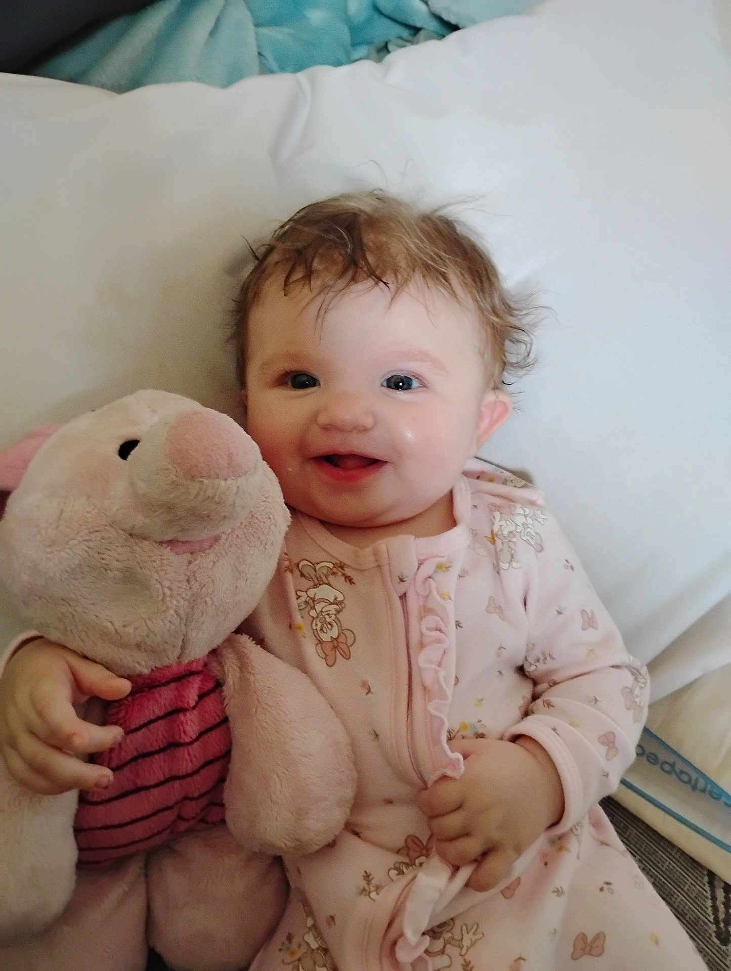 Nova is registered to the contest to win money with this photo: baby, child, smiling, plush_toy, pink_clothing, bed, cute, happy, infant, cuddling, soft_toy, onesie, portrait, indoors, toy, childhood, sleepwear, joyful, person, face