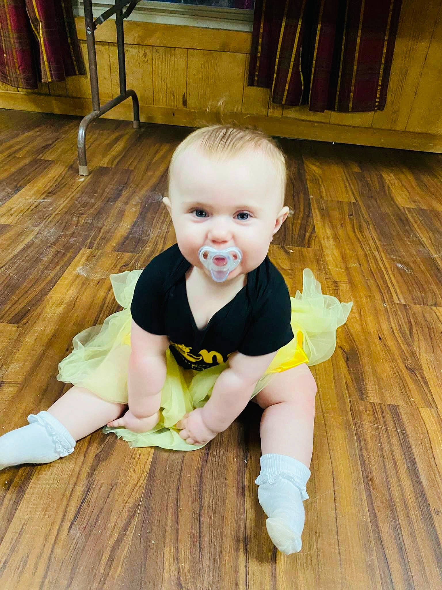 Scarlett is registered to the contest to win money with this photo: baby, baby_toddler_clothing, bench, cheek, child, eye, floor, flooring, happy, hardwood, laminate_flooring, leg, person, skin, sleeve, sock, thigh, toddler, wood, wood_flooring