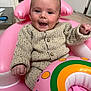 baby, infant, child, smile, happy, pink, inflatable_ring, sweater, knit_sweater, cozy, cute, portrait, face, eyes, mouth, hand, seat, indoor, toy, flooring