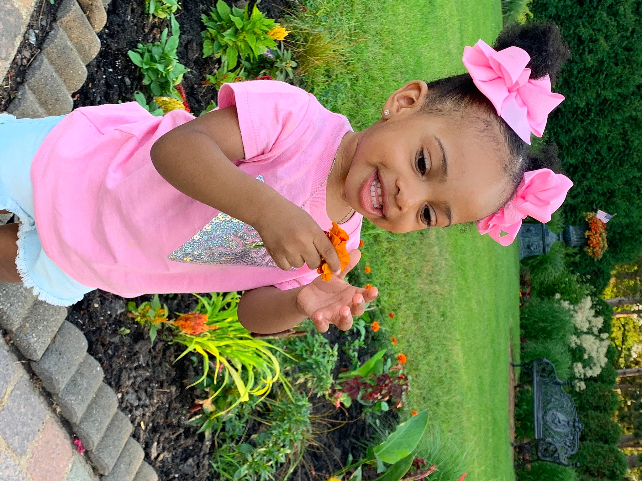 Kylie Lynn is registered to the contest to win money with this photo: annual_plant, botany, child, facial_expression, flower, fun, grass, green, happy, hat, joy, leaf, leisure, people, people_in_nature, person, petal, pink, plant, smile