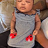 Zuri is registered to the contest to win money with this photo: baby, child, sleeping, portrait, striped_outfit, dress, ladybug, pink_socks, socks, pillow, couch, adult, arms, indoors, closeup, peaceful, infant, seated, fashion, nap