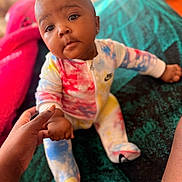Zuri joined the competition — help win amazing prizes! baby, infant, child, sitting, portrait, face, eyes, smiling, curious, indoor, couch, blanket, colorful, clothing, onesie, sock, adult_hand, family, closeup, photography