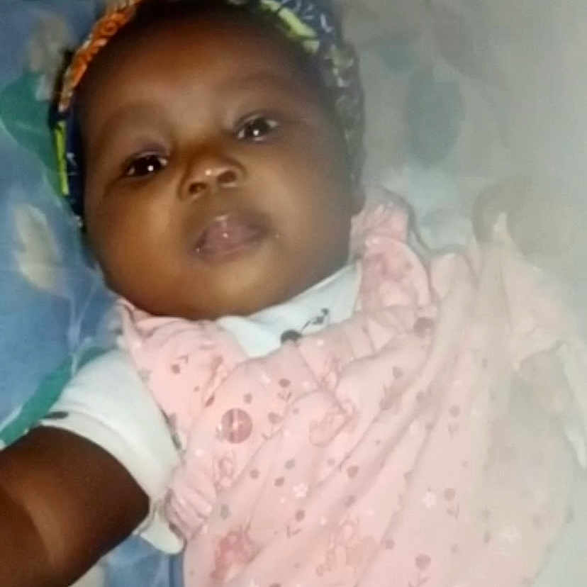 Princia a rejoint le concours — aidez-le/la à gagner de superbes lots ! baby, blanket, child, closeup, clothing, cozy, cute, expression, face, floral_pattern, head_wrap, indoors, infant, lying_down, person, pink_bib, portrait, sleepwear, soft_lighting, young_child