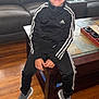 Damon joined the competition — help win amazing prizes! adidas, boy, casual_clothing, child, coffee_table, comfortable, couch, furniture, happy, home, indoor, living_room, person, portrait, sitting, smiling, sneakers, tracksuit, wooden_floor, young