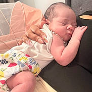 Allison joined the competition — help win amazing prizes! adult_hand, baby, blanket, chair, child, closeup, cozy, curled_up, family, floral_clothing, hand, indoors, infant, manicure, newborn, onesie, peaceful, portrait, resting, sleeping