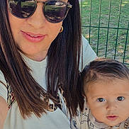 Luis a rejoint le concours — aidez-le/la à gagner de superbes lots ! baby, casual_clothing, child, cute, daylight, face, fence, grass, hair, holding, nature, outdoor, park, person, portrait, smile, sunglasses, sunlight, toddler, woman