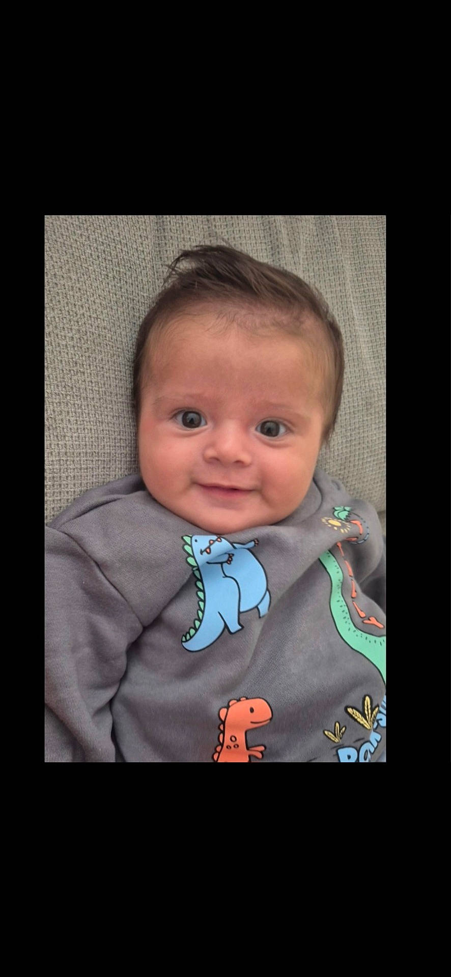 Luis a rejoint le concours — aidez-le/la à gagner de superbes lots ! baby, casual, child, clothing, colorful, cute, dinosaur_print, eyes, face, happy, indoors, infant, person, portrait, sitting, smiling, soft_background, sweater, texture, young